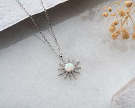 Handmade lunar pendant necklace on a celestial-themed jewelry display.