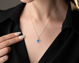 Lifestyle image of a celestial necklace styled with other astrology-inspired jewelry pieces.
