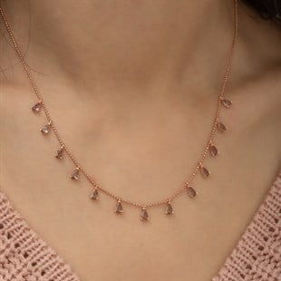 Rose gold necklace on a person wearing a pink crochet top
