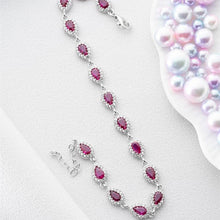Silver necklace with pink gemstones on a light gray background
