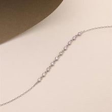 Silver chain necklace on a beige background