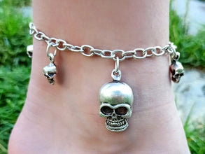 Silver skull anklet on a foot with a blurred natural background