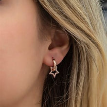 Close-up of a person wearing a star-shaped earring.