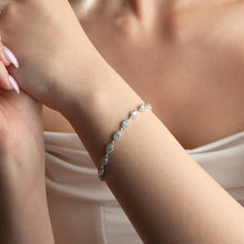 Silver bracelet on a person's wrist with a soft focus background