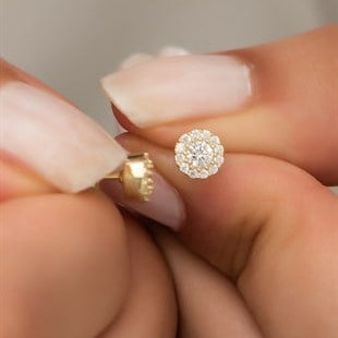 Close-up of a hand holding a diamond earring.