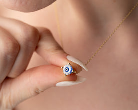 Light-reflecting Evil Eye pendant showcasing a deep blue gemstone, symbolizing wisdom and protection.