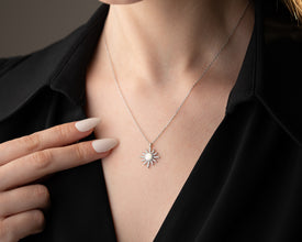 Lifestyle image of a celestial necklace styled with other astrology-inspired jewelry pieces.