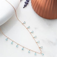 Delicate necklace with blue gemstones on a white surface