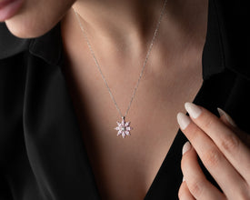 A timeless sterling silver pendant featuring a blooming magnolia flower with a soft pink gemstone accent.