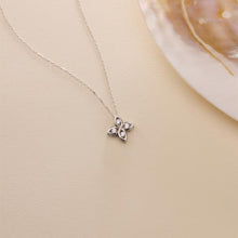 Butterfly-shaped pendant necklace on a beige background