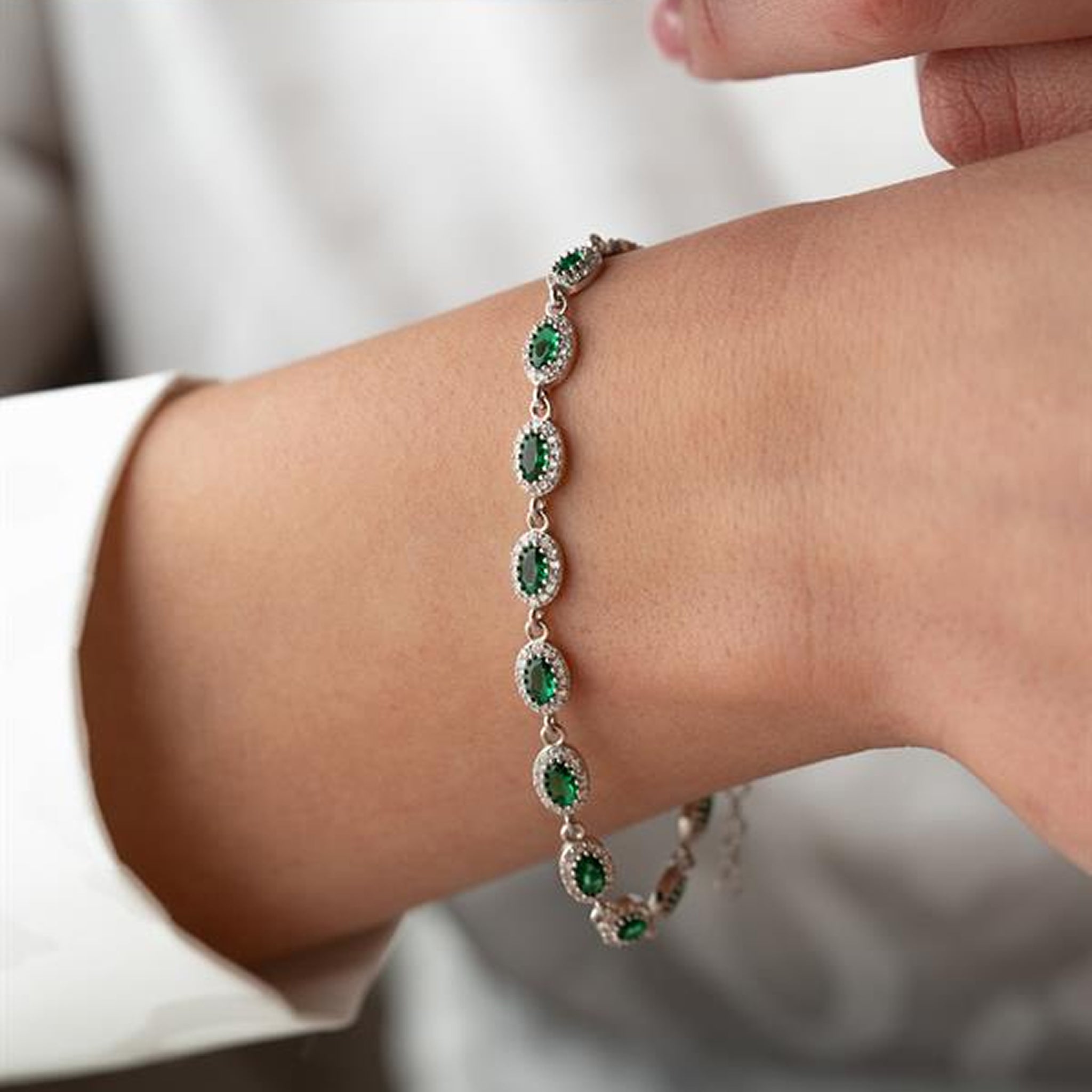 Close-up of a person's wrist wearing a green gemstone bracelet.