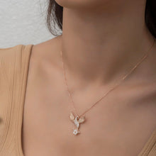 Rose gold necklace with a delicate pendant worn by a person