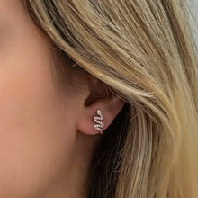 Close-up of a person wearing a diamond earring with blonde hair.