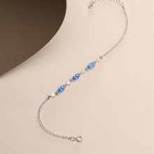 Silver bracelet with blue gemstones on a beige background