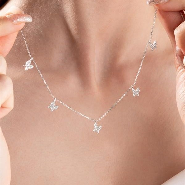 Silver butterfly necklace on a person's neck