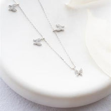 Silver butterfly necklace on a white plate