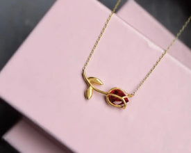 Minimalist silver tulip necklace with a fiery garnet gemstone centerpiece.