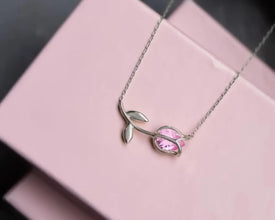 Close-up of a tulip-shaped silver pendant with a radiant pink tourmaline stone.