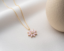 A timeless floral pendant featuring a blooming magnolia design with gemstone sparkle.