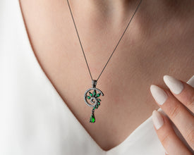 Gothic Christmas flatlay with emerald pendant and dried roses