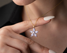 Close-up of a sterling silver floral necklace, featuring an intricate lavender bloom.