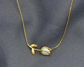 Elegant botanical-inspired jewelry piece with opal stone