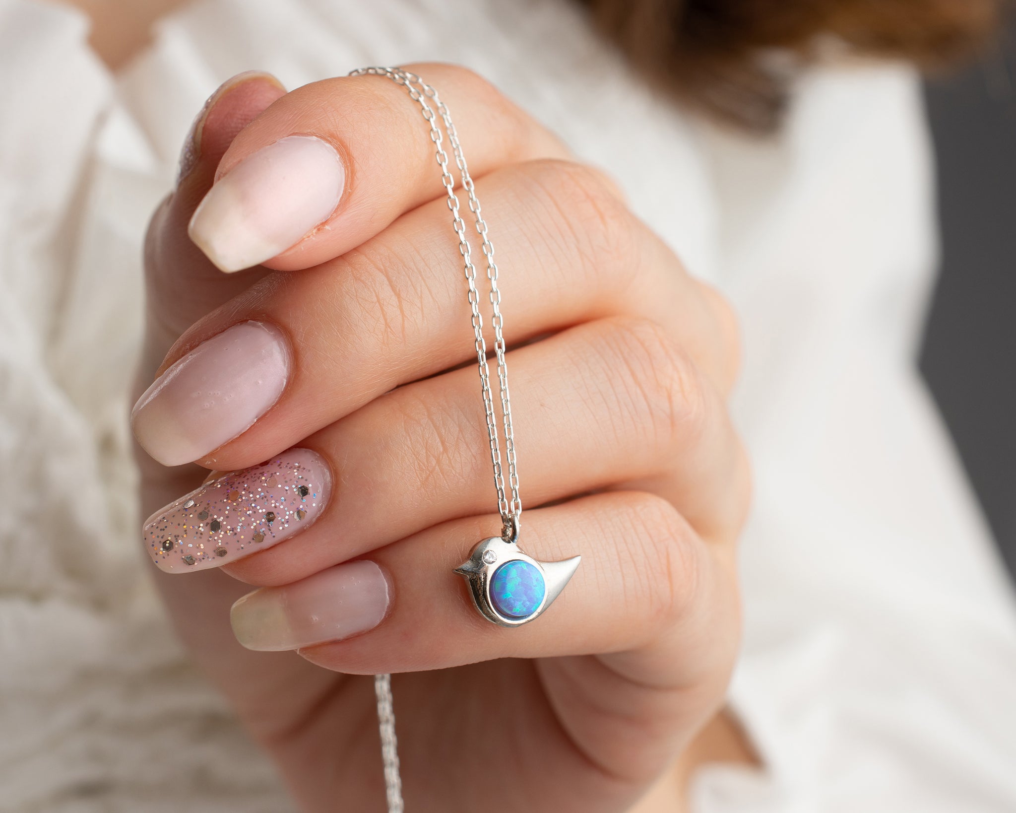 A meaningful opal necklace with a bird charm, ideal for self-care and empowerment.