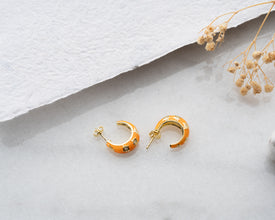 Sunset-inspired hoop earrings glowing with galaxy hues, a perfect astrology statement piece.