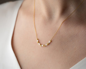 Flat lay of elegant white gemstone necklace with props