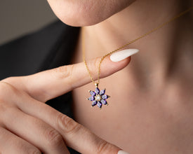 A handcrafted sterling silver necklace with a nature-inspired amethyst charm.