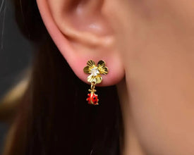 Minimalist gold-plated floral earrings with a dainty ladybug charm.