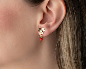 Close-up of intricate ladybug and floral design on dangle earrings