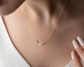 Layered pearl necklace styled with other minimal jewelry