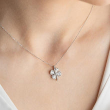 Silver four-leaf clover necklace on a person's neck