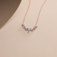 Rose gold necklace with blue stones on a beige background