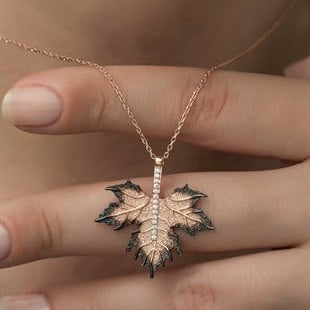 Rose gold leaf-shaped necklace on a hand