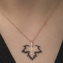 Necklace with a leaf-shaped pendant on a person's neck