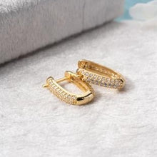 Gold hoop earrings on a textured surface