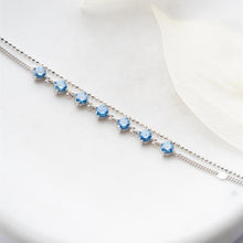 Silver bracelet with blue gemstones on a white background