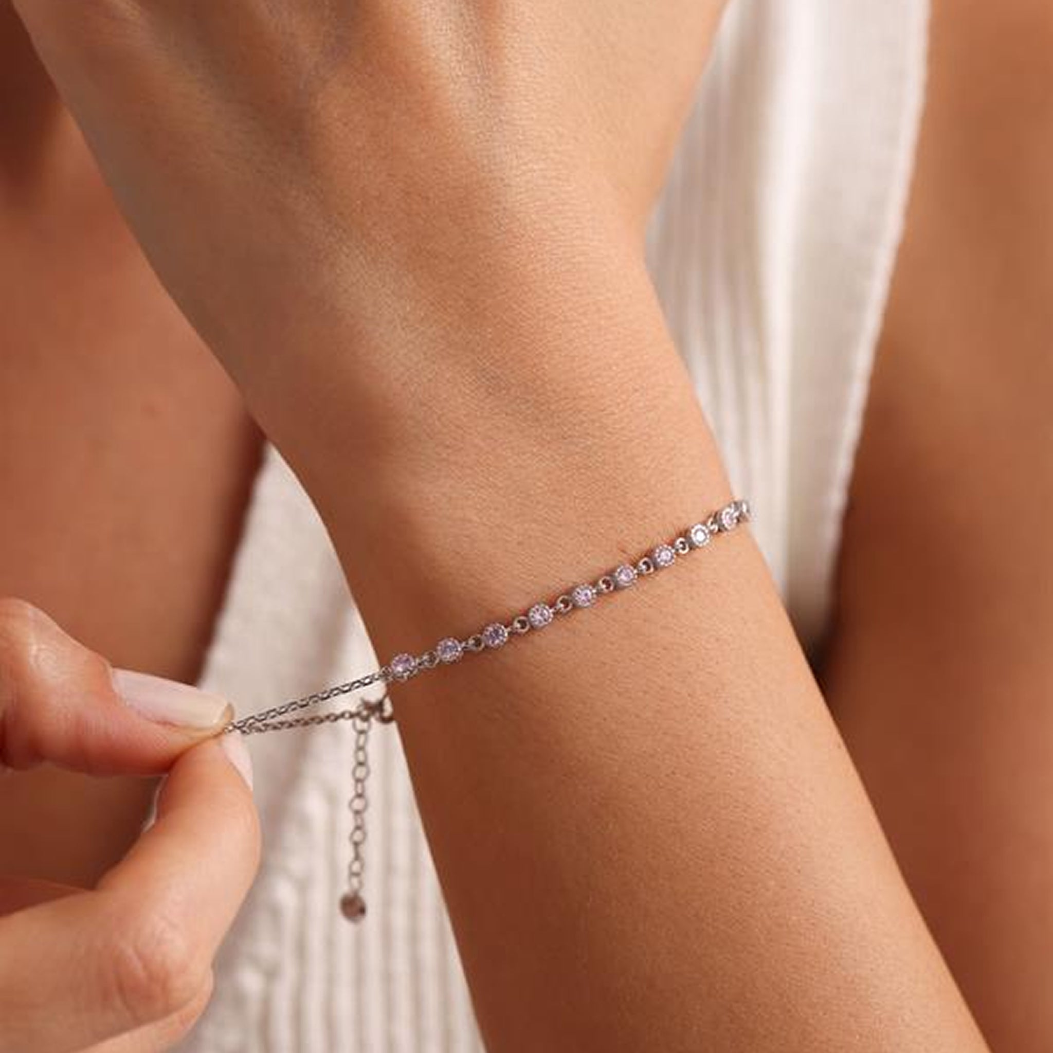 Close-up of a person wearing a delicate bracelet with a blurred background