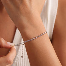 Close-up of a person wearing a delicate bracelet with a blurred background