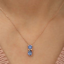 Rose gold necklace with a blue gemstone on a person's neck