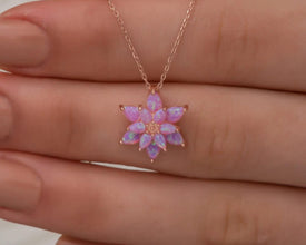 Close-up of an intricately designed sterling silver lotus necklace featuring a fire opal gemstone.